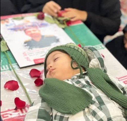 آرامش نوه «شهید تولی» روی تابوت پدربزرگ
